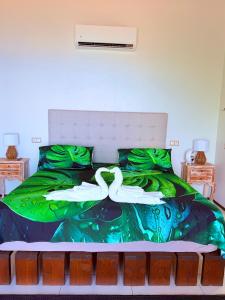 a bedroom with a bed with two swans on it at Villa Maeva Tahiti in Vaihi +17 photos