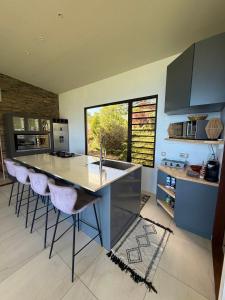 a kitchen with a large island with bar stools at Villa Maeva Tahiti in Vaihi