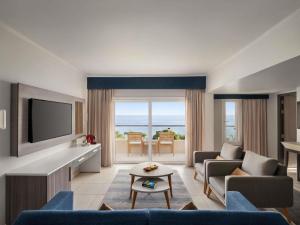a living room with a couch and a tv at Mercure Ismailia Forsan Island in Ismailia
