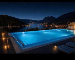 a swimming pool at night with a view of the water at Lake View 49 in Sale Marasino