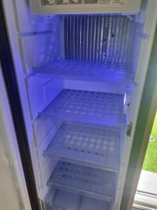 an empty refrigerator with blue shelves in it at Kościelnik Camp in Kościelnik