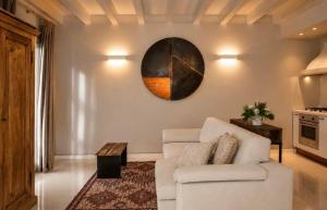 a living room with a couch and a clock on the wall at Lake View 49 in Sale Marasino
