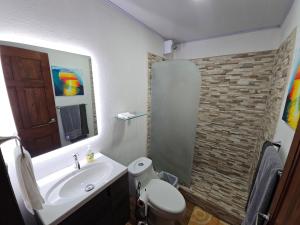 a bathroom with a sink and a toilet and a mirror at Outback Hermosa in Playa Hermosa +11 photos