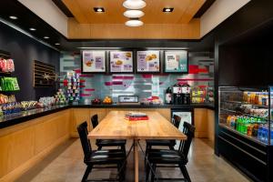 a restaurant with a wooden table and a bar at Aloft by Marriott Richmond West Short Pump in Short Pump