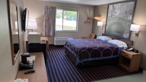 a hotel room with a bed and a window at Northwoods Inn and Suites in Ely