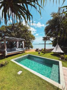 a swimming pool in a yard next to the ocean at Villa Mitirapa in Tohautu