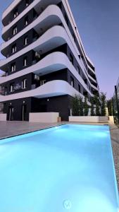 a building with a swimming pool in front of a building at Kron Apart Hotel Golem in Golem