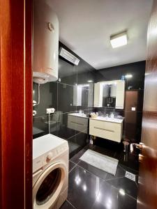 a bathroom with a washing machine and a sink at Central Point Apartment in Bar +35 photos