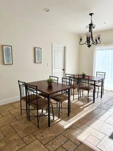 a dining room with tables and chairs and a chandelier at Qazaq Hostel in Los Angeles