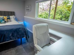 a room with a chair and a bed and a window at Remodeled 2BR, Chic and Cozy in Shoreline