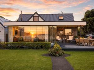 ein Haus mit Blick auf den Sonnenuntergang in der Unterkunft Blackpool Bayside - Stay Waiheke in Oneroa