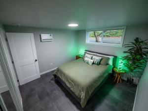 a bedroom with a bed with green walls and a window at Remodeled 2BR, Chic and Cozy in Shoreline
