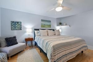 a white bedroom with a bed and a chair at Limestone Edge by Simple Life Rentals in Baileys Harbor