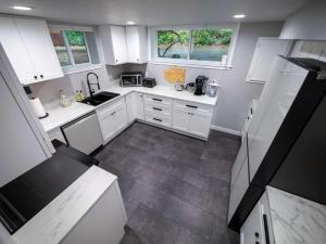 a kitchen with white cabinets and a tile floor at Remodeled 2BR, Chic and Cozy in Shoreline +11 photos