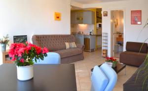 un soggiorno con divano e tavolo con fiori di Anna Apartment a Budaörs