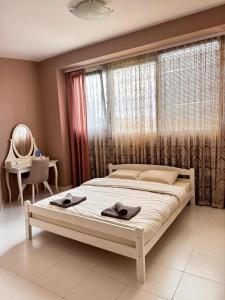a bedroom with a bed with two towels on it at Central Point Apartment in Bar