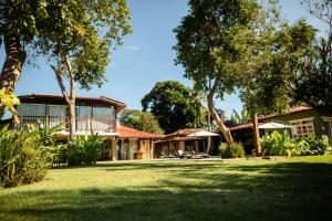an exterior view of a house with a yard at Pousada Villa Tainá - Arraial d'Ajuda, Bahia in Arraial d'Ajuda