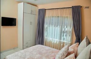 a bedroom with a bed and a large window at Mirai Apartments in Harare +11 photos