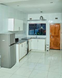 a kitchen with white cabinets and a sink at Mirai Apartments in Harare