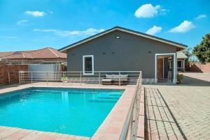a swimming pool in front of a house at Mirai Apartments in Harare