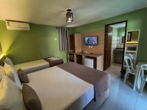 a hotel room with two beds and a bathroom at Hotel Coco Beach in Conde