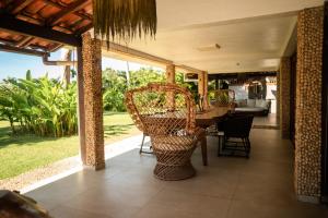 an open porch with a table and chairs on it at Pousada Villa Tainá - Arraial d'Ajuda, Bahia in Arraial d'Ajuda