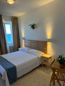 a bedroom with a bed and a table and a window at Castello Di Marà in Cupra Marittima