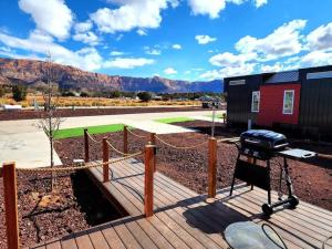 a grill on a wooden deck with mountains in the background at Zion Couples Retreat Romantic Desert Tiny Home in Apple Valley