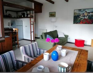 a living room with a table with a vase with flowers on it at Casa Cicala in Trarego