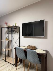 a living room with a table and a tv on a wall at Dimora Leonida in Taranto