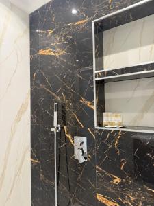 a bathroom with black marble walls and a mirror at Dimora Leonida in Taranto