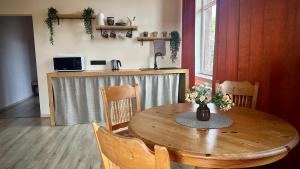 a wooden table with a vase of flowers on it at Kuldiga Kalna Apartment in Kuldīga