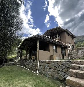 a house with a stone wall next to a building at Aldealma in Pisac