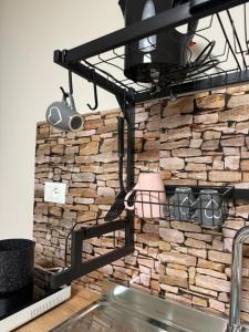 a shelf on a brick wall with pots and pans at Dimora Leonida in Taranto +20 photos
