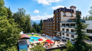 a hotel with a swimming pool in front of a building at Sputnik Hotel Batumi in Batumi
