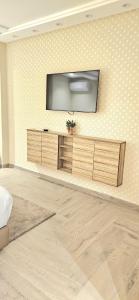 a living room with a television on a wall at Andre Luxury Apart in Laayoune