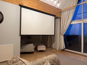 a large screen in a living room with a couch at Lake View Lodge in Saint Columb Major