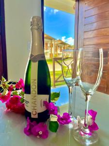 a bottle of champagne and two glasses on a table at Chalé Átina - Atins in Atins