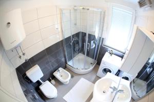 ein Badezimmer mit Dusche, Waschbecken und Toilette in der Unterkunft Apartment Zubčić in Zadar