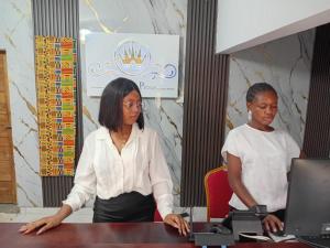 two women sitting at a table with a laptop at HOTEL DU PRINCE Bingerville in Bingerville