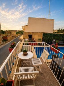 a table and chairs on a balcony with a view of a street at Ta Speranza Farmhouse in Victoria +6 photos