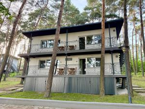 a house with a balcony in the middle of trees at Turawa Lake Residence in Turawa