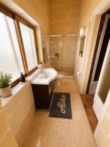 a bathroom with a sink and a toilet and a shower at Ta Speranza Farmhouse in Victoria