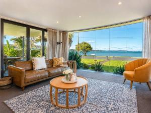 ein Wohnzimmer mit Sofa und Tisch in der Unterkunft Blackpool Bayside - Stay Waiheke in Oneroa