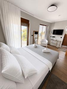 a large white bed with white pillows and a room at Sunny Seaside Villa-90 m from beach in Kriopigi +58 photos