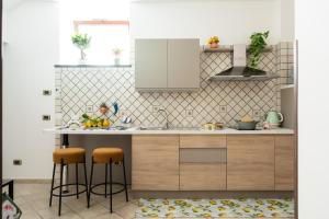 a kitchen with a counter and stools in it at GrandPa's House in Sorrento