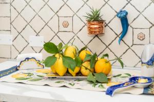 a pile of lemons on a plate on a table at GrandPa's House in Sorrento