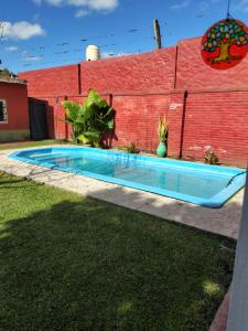 a swimming pool in a yard next to a brick wall at Lo de Xime in Yerba Buena