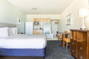 a hotel room with a bed and a kitchen at Beachside Resort Panama City Beach in Panama City Beach