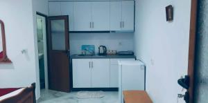 a kitchen with white cabinets and a refrigerator at Guest House Luani in Ksamil